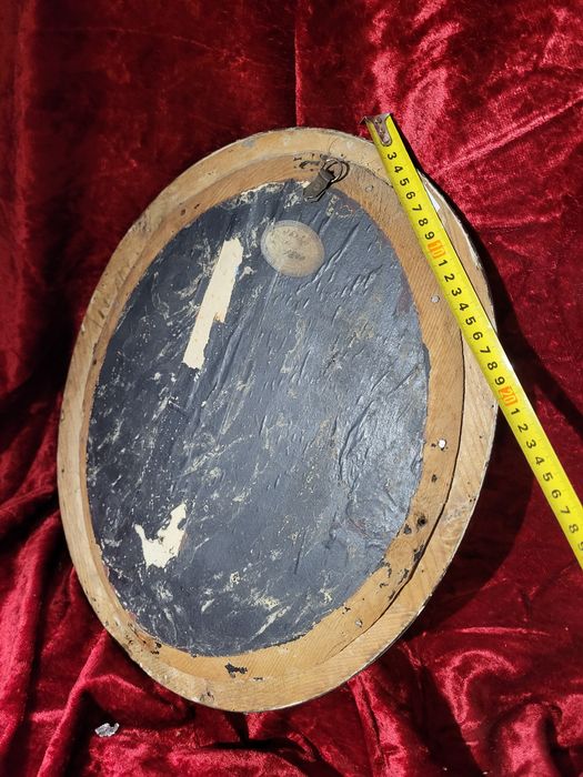 Stary krzyż w owalnej ramie za szkłem