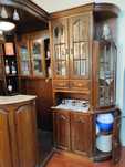 Bar de canto com vidros facetados, balcão, vitrines e 2 bancos
