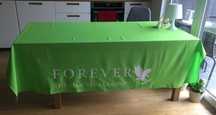 Zielony obrus z nadrukiem Forever Living Products.