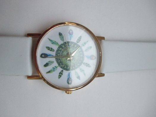 Relógio dourado com penas em fundo branco (NOVO)