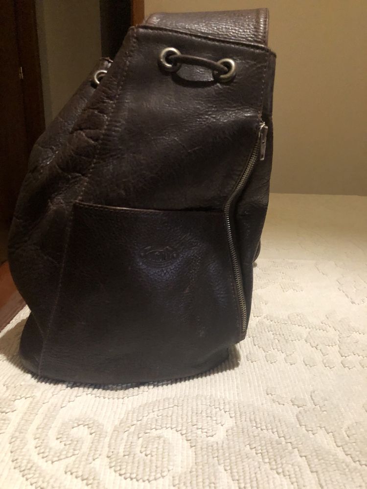 Mochila em pele castanha e bolsa preta . Ambas em pele