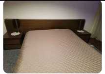 Cama de casal com mesinhas de cabeceira.