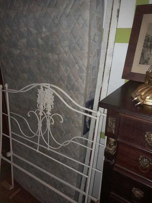 Cama com cómoda com candeeiros e quadros