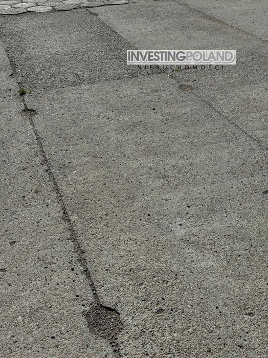 Plac utwardzony, ogrodzony, wyłożony płytami betonowymi , hala