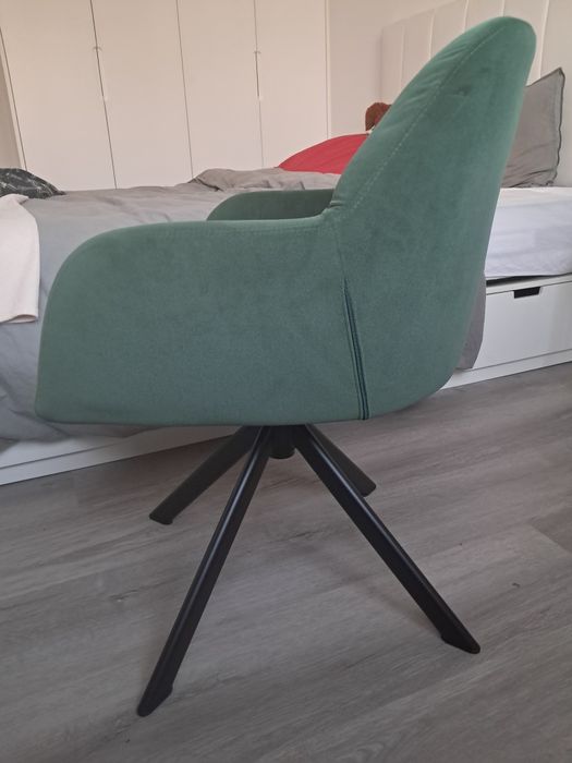 Cadeira giratória verde com pernas de aço preto.