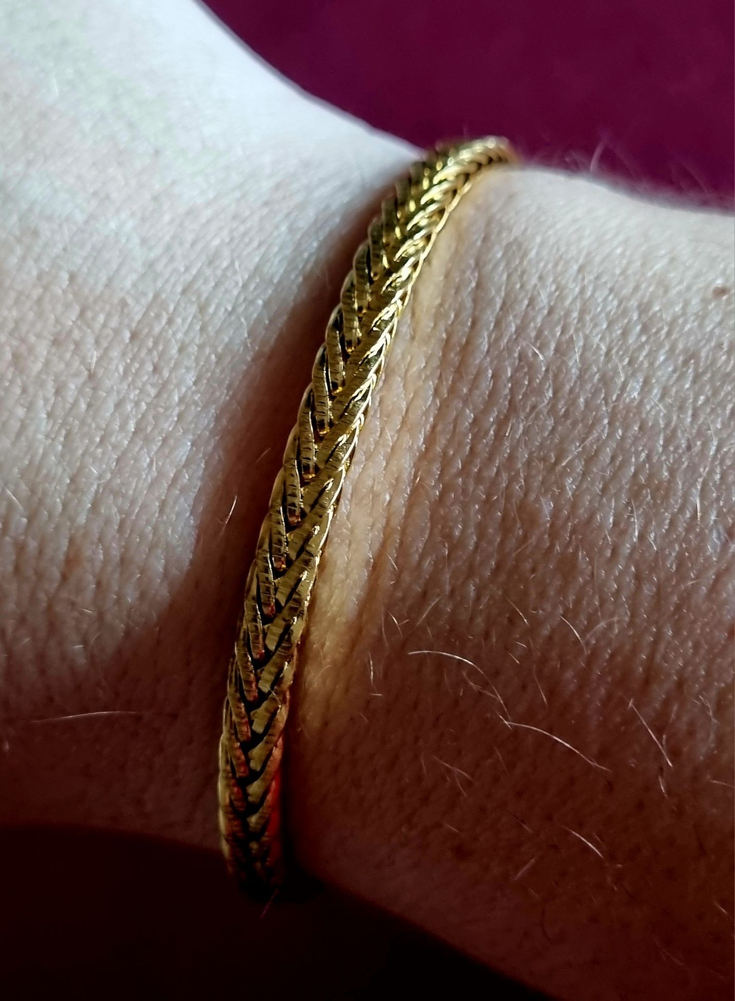 Pulseira dourada, em aço inoxidável. Tem extensor