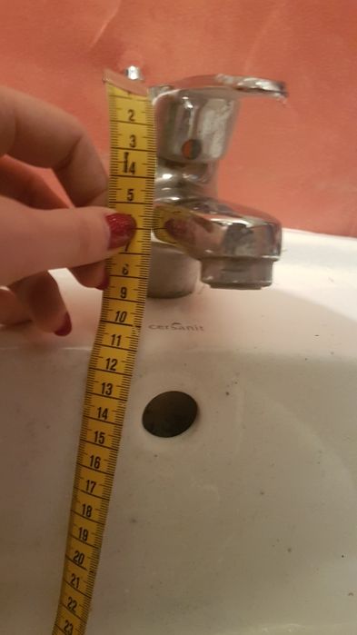 Umywalka biała z baterią i rurkami