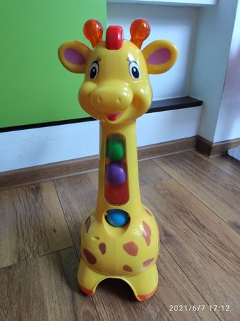 Żyrafa z piłeczkami jeździ pchacz