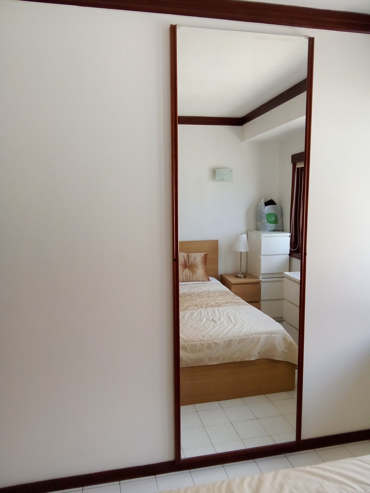 Cama. Espelho. Gaveta