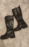 Botas pretas com fivela e corrente