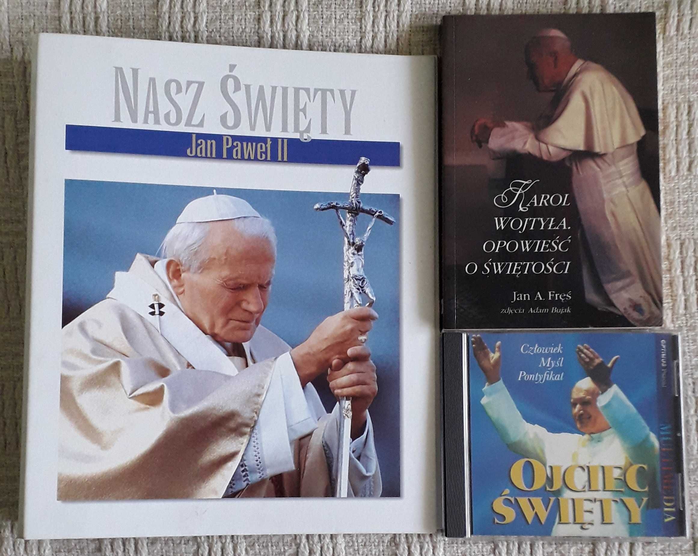 Jan Paweł II, segregator, płyta CD, książka o Karolu Wojtyle.