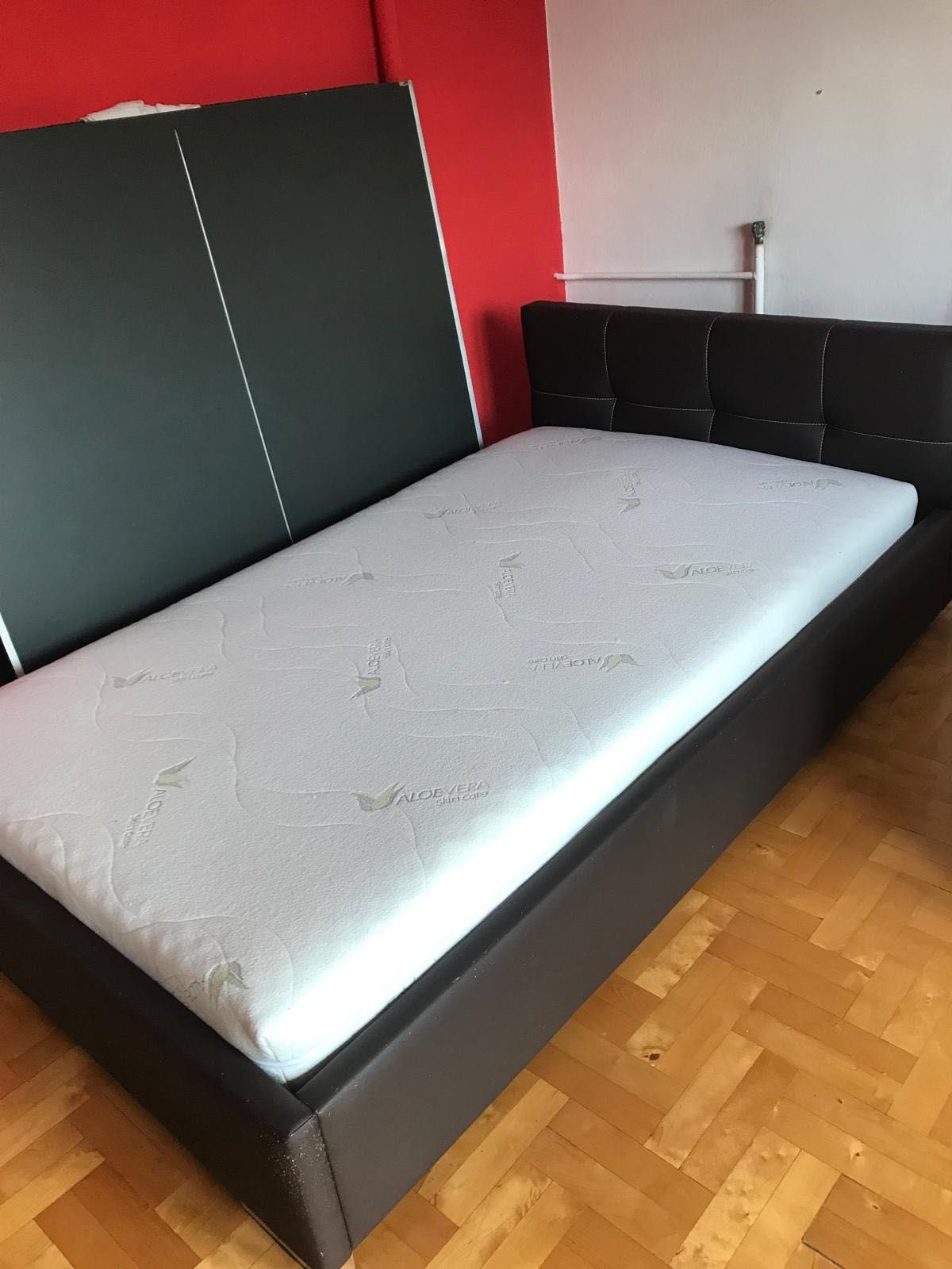 Łóżko podwójne z materacem i pokrowcem.