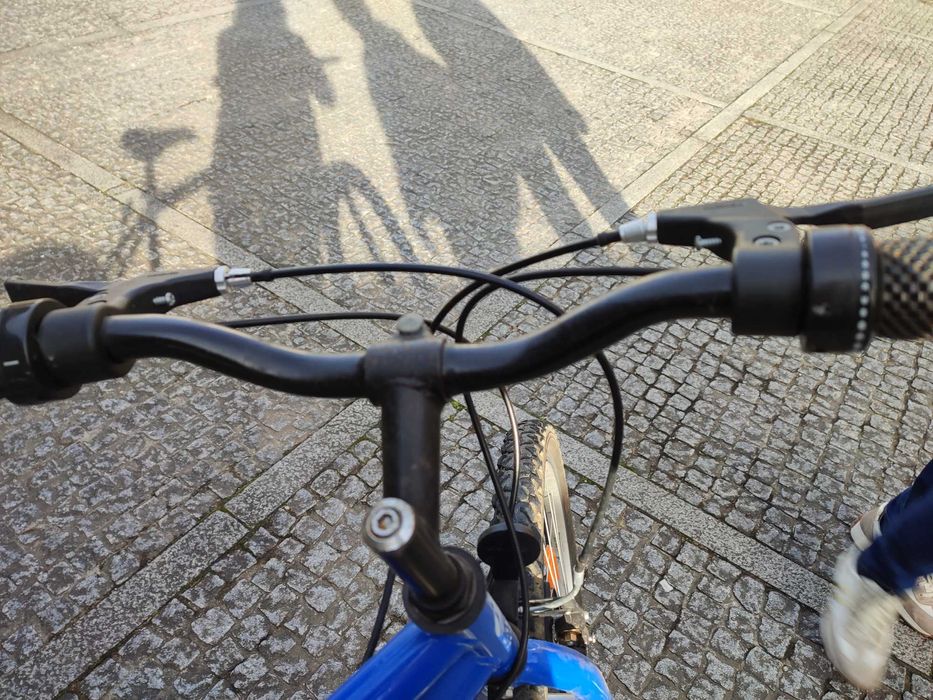 Bicicleta de montanha azul com mudanças e travões Shimano
