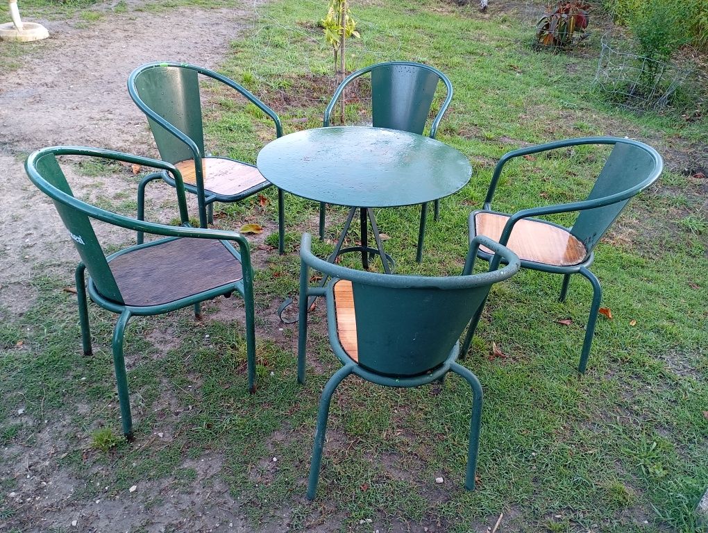 Mesa com 5 cadeiras antigas.