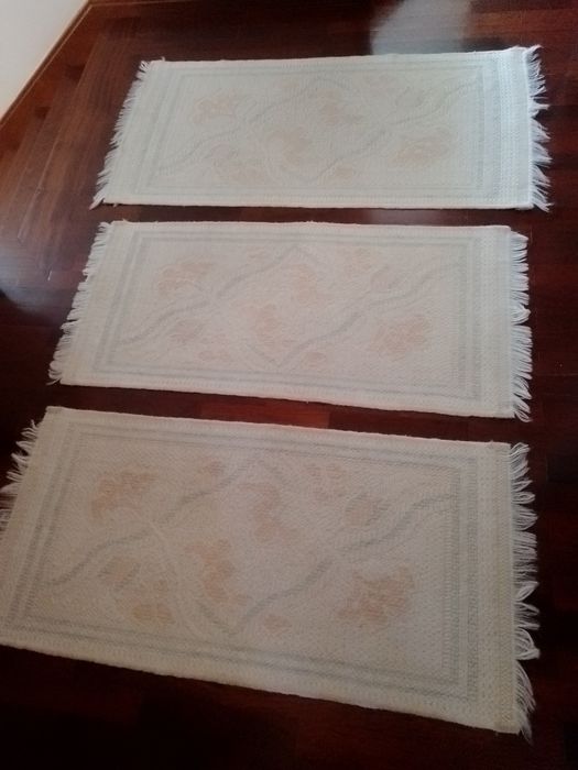 Três tapetes em branco e rosa.