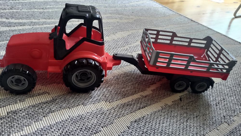 Czerwony traktor z przyczepką
