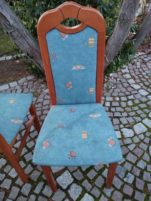 Owalny, rozkładany stół do salonu lub jadalni z krzesłami.