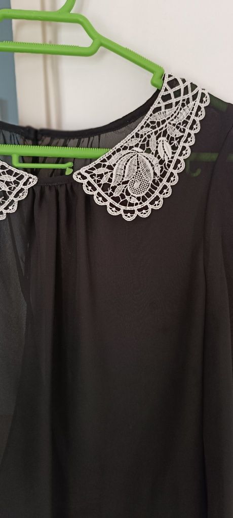 Camisa preta com gola bordada em branco. Aberta atrás. Tecido transpar
