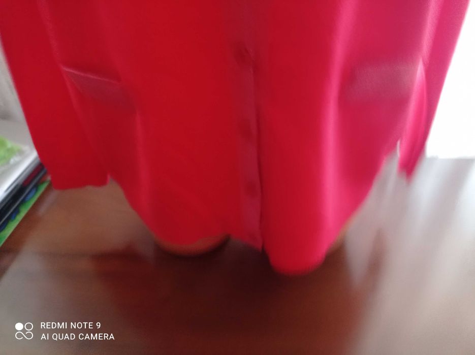 Duży ładny czerwony, damski sweterek z ozdobnym zapięciem.