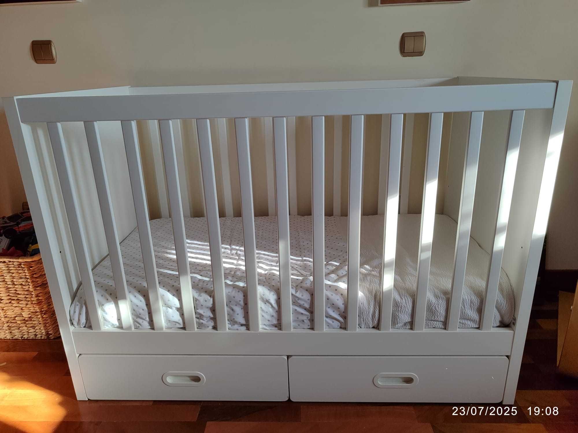 Cama de bebé com grades de proteção.