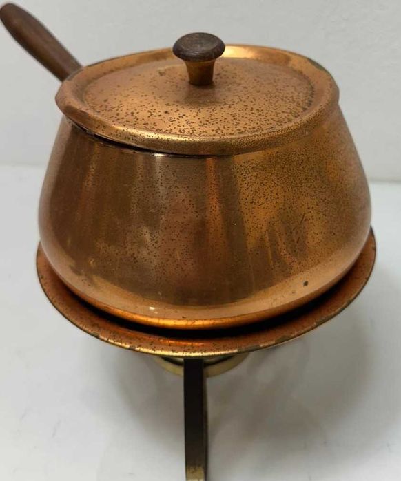 Caçarola em cobre assente em trempe de latão com lamparina.