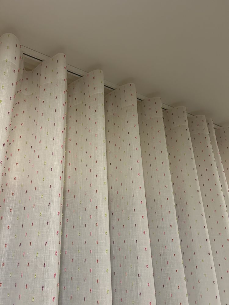 Cortinas brancas com pontos rosa, roxo, verde