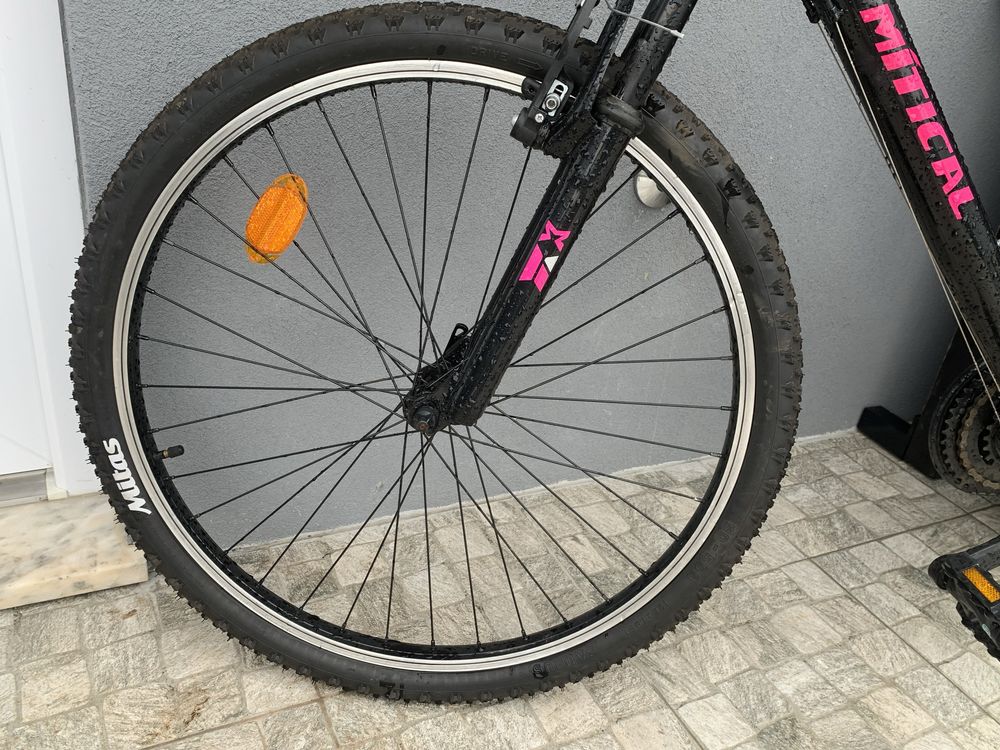 Bicicleta preta com alguns detalhes em rosa