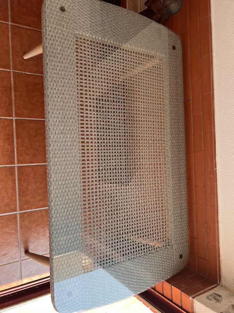 Mesa de exterior com tampo de vidro.