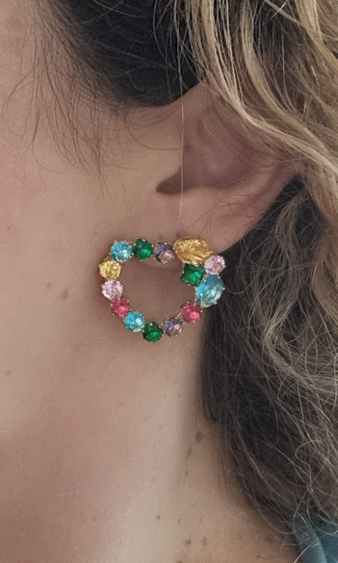 Brincos dourados, de pico, com pedras de vidro coloridas.