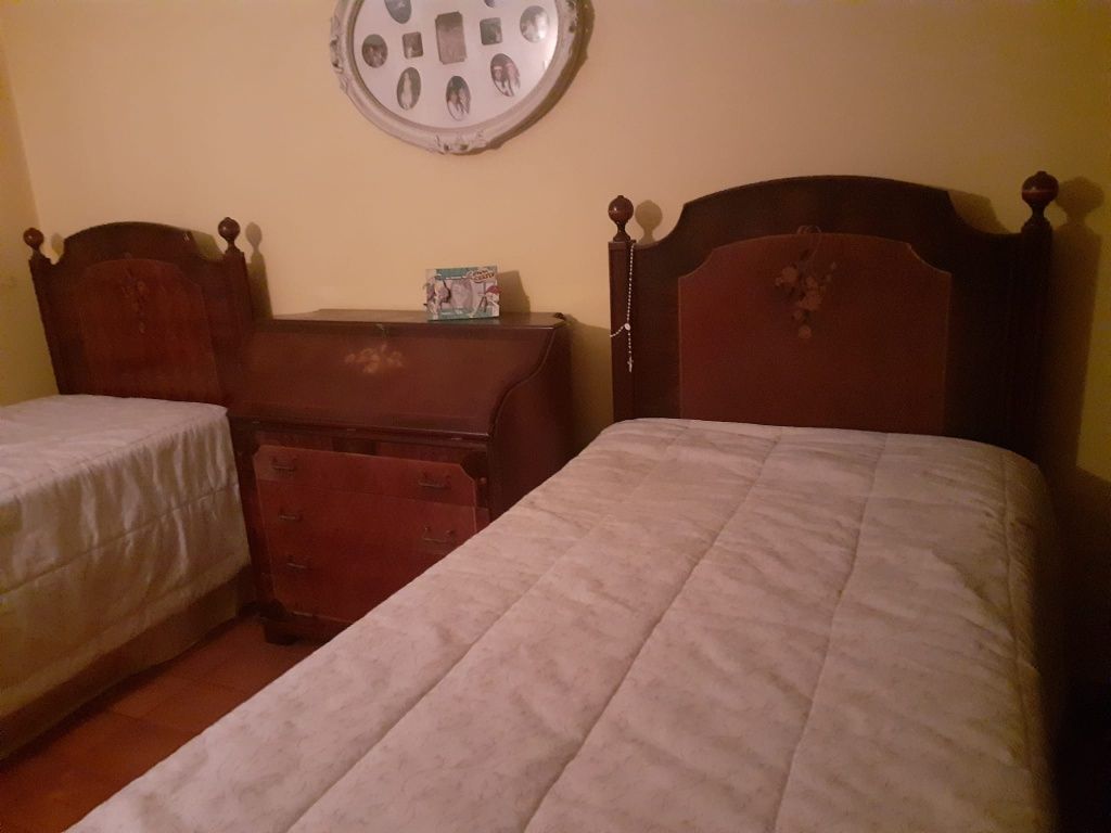 Quarto com 2 camas, escrivanhina e uma mesinha de cabeceira