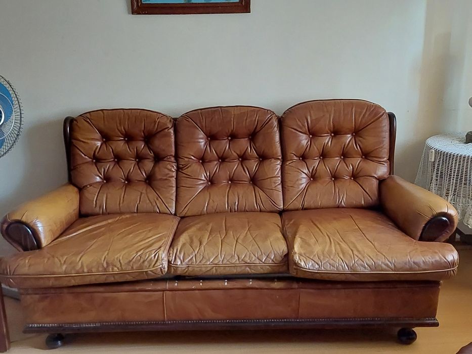 Sofá cama de três lugares e duas poltronas em pele.