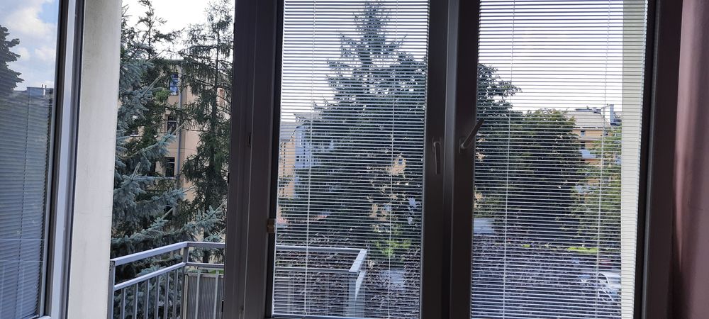Okno balkonowe z roletami i parapetem