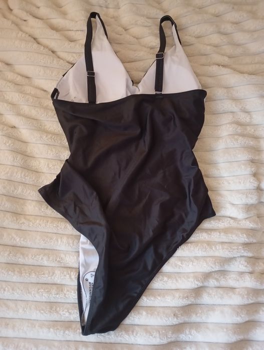 Купальник суцільний, чорний з білими вставками.