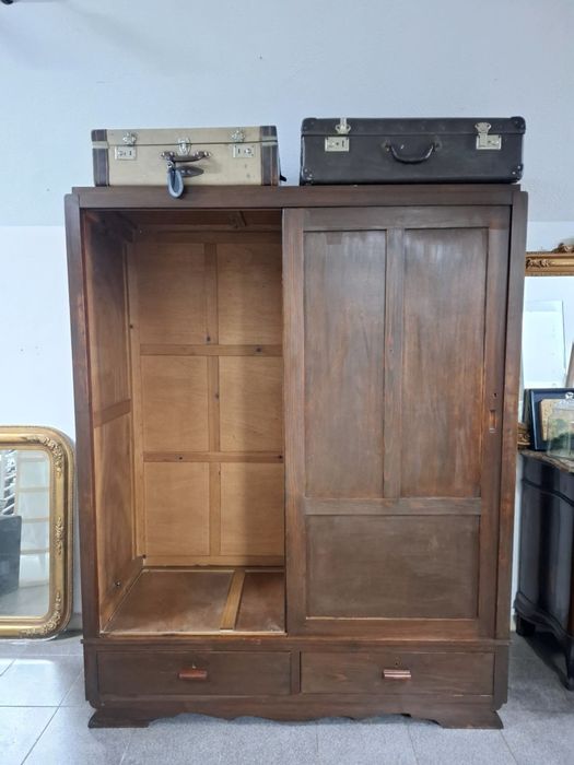 Roupeiro em madeira maciça com portas de correr.