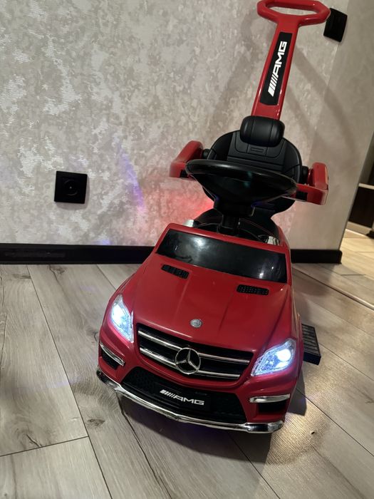 Дитяча каталка толокар на якій грає музика, світяться фари