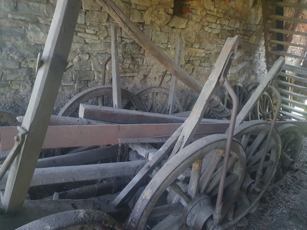 2 drewniane wózki, maszyny rolnicze, 6 zabytkowych drewnianych kół