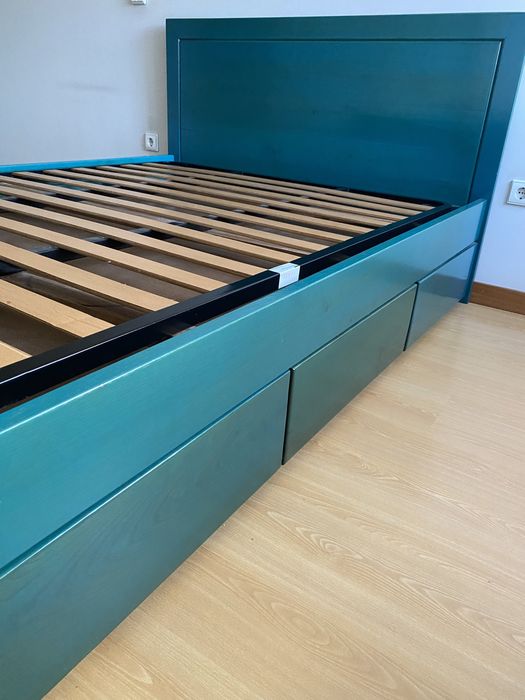 Cama em madeira de castanho pintada em azul a ver o veio da madeira