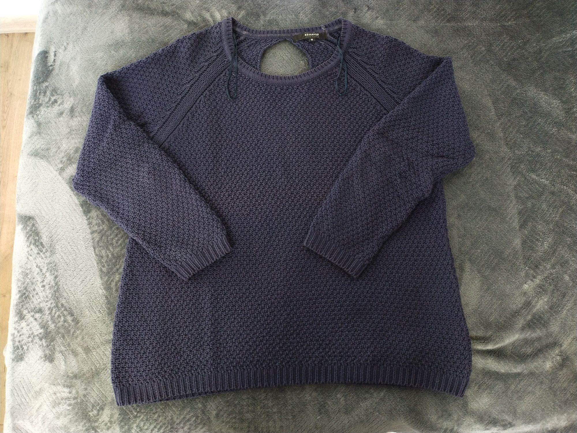 Granatowy sweter z wycięciem w kształcie łezki na plecach. 
Wymiary wy