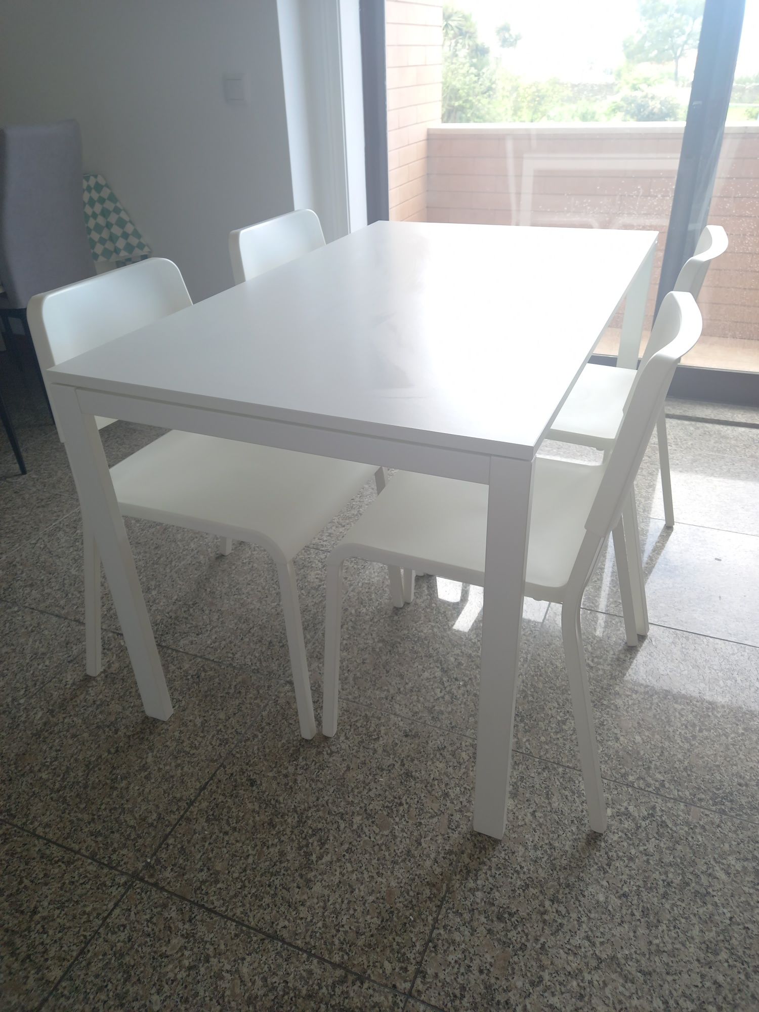 Mesa com quatro cadeiras brancas