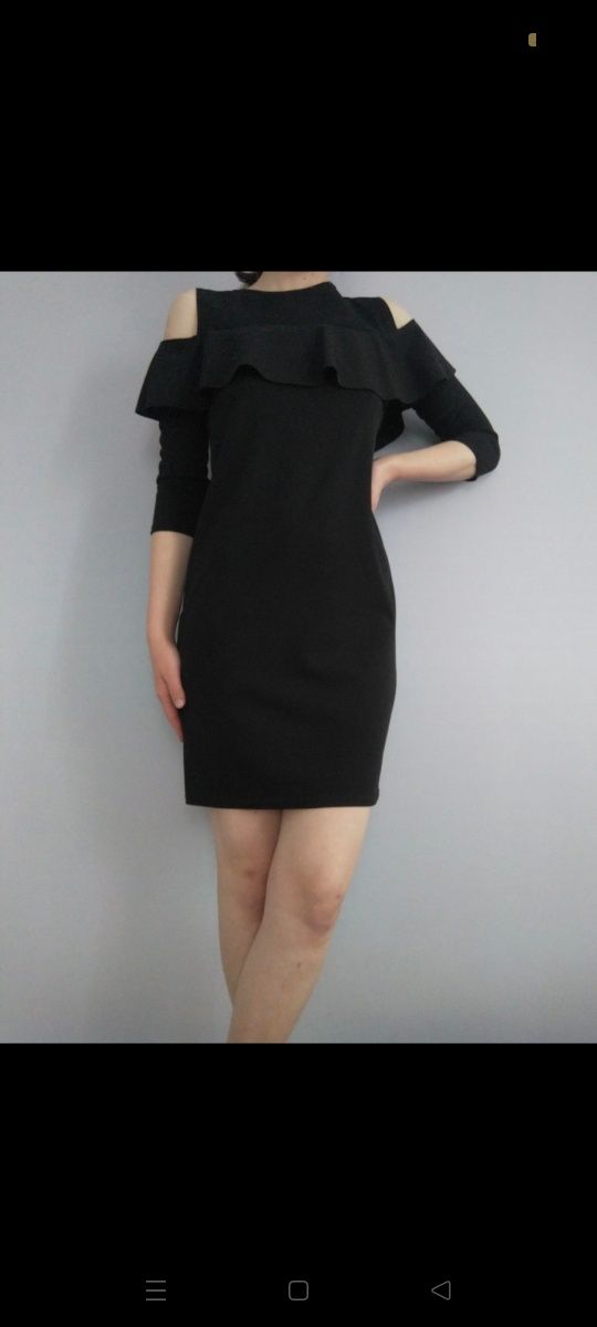 czarna sukienka z odkrytymi ramionami i falbanką