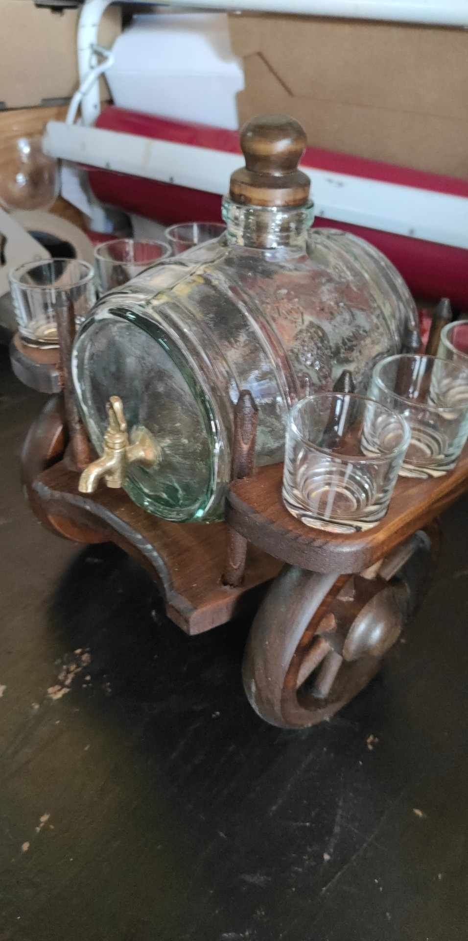 Carroça antiga em madeira com barril em vidro trabalhado e copos