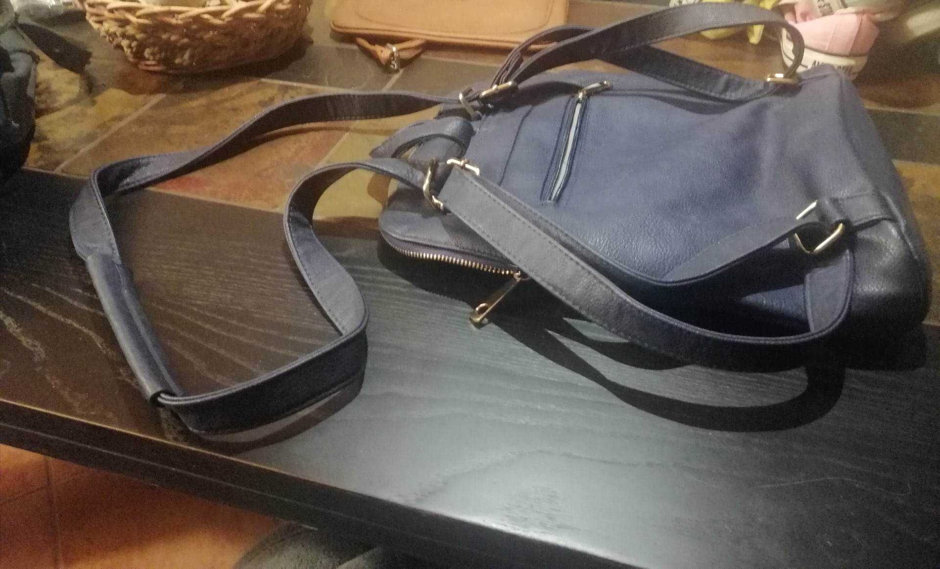 Uma mala/mochila de cor azul escuro e uma mala pequena de cor castanha