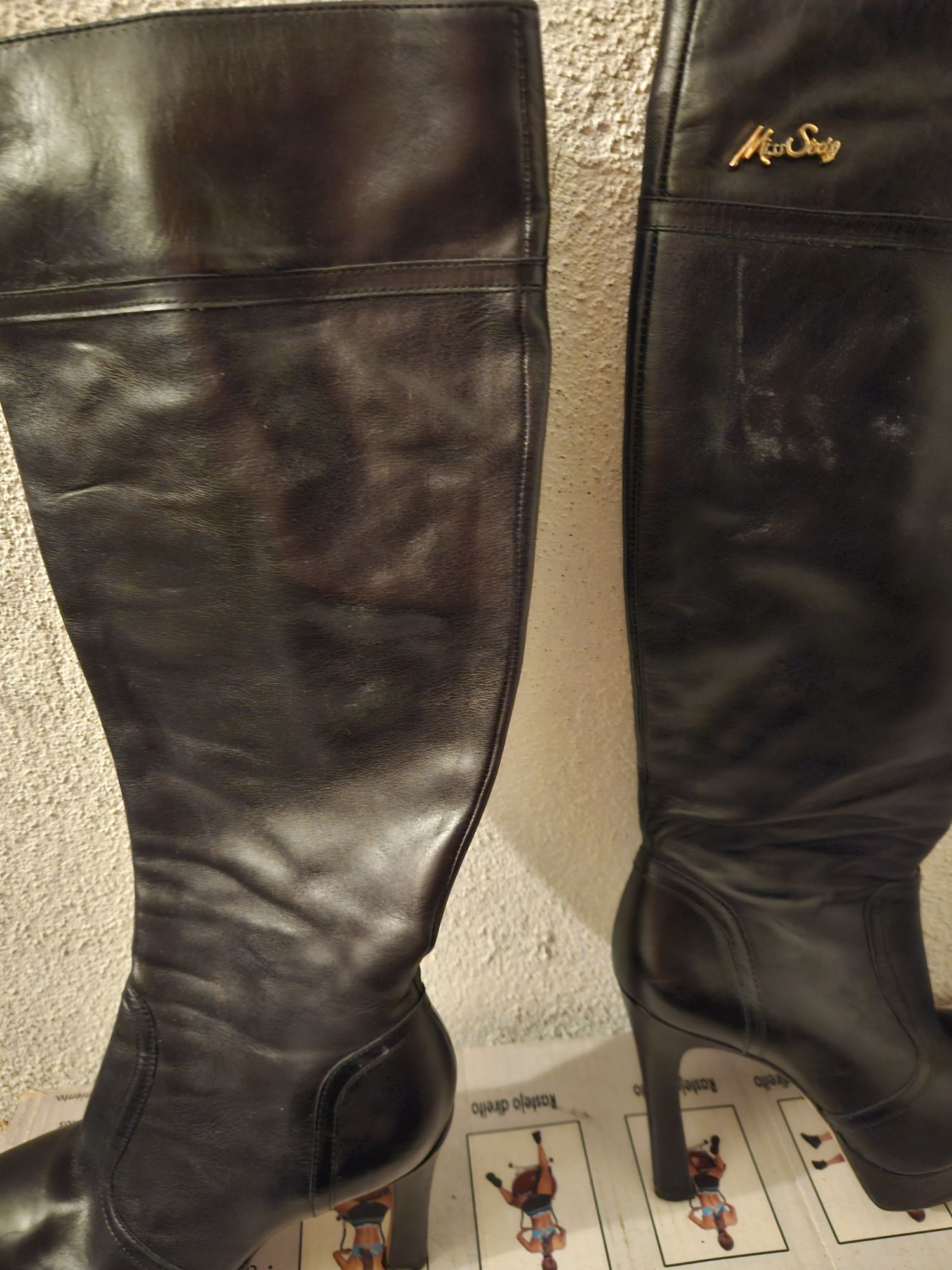 Botas cano alto em pele preta.  Miss Sixty