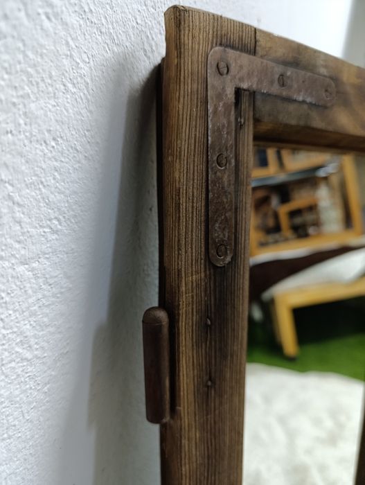 Lustro w starej drewnianej ramie okiennej.