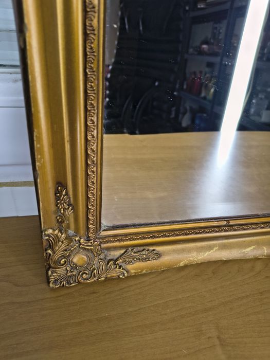 Lustro w ozdobnej złotej ramie