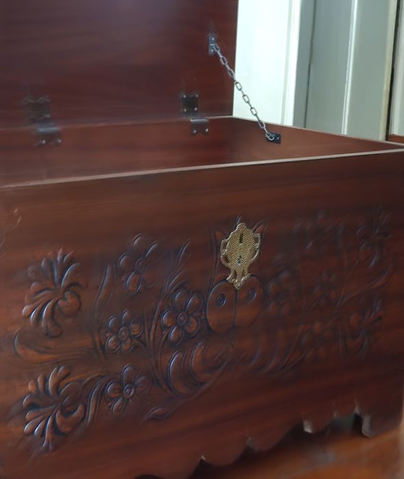 Baú em madeira com motivos em relevo.