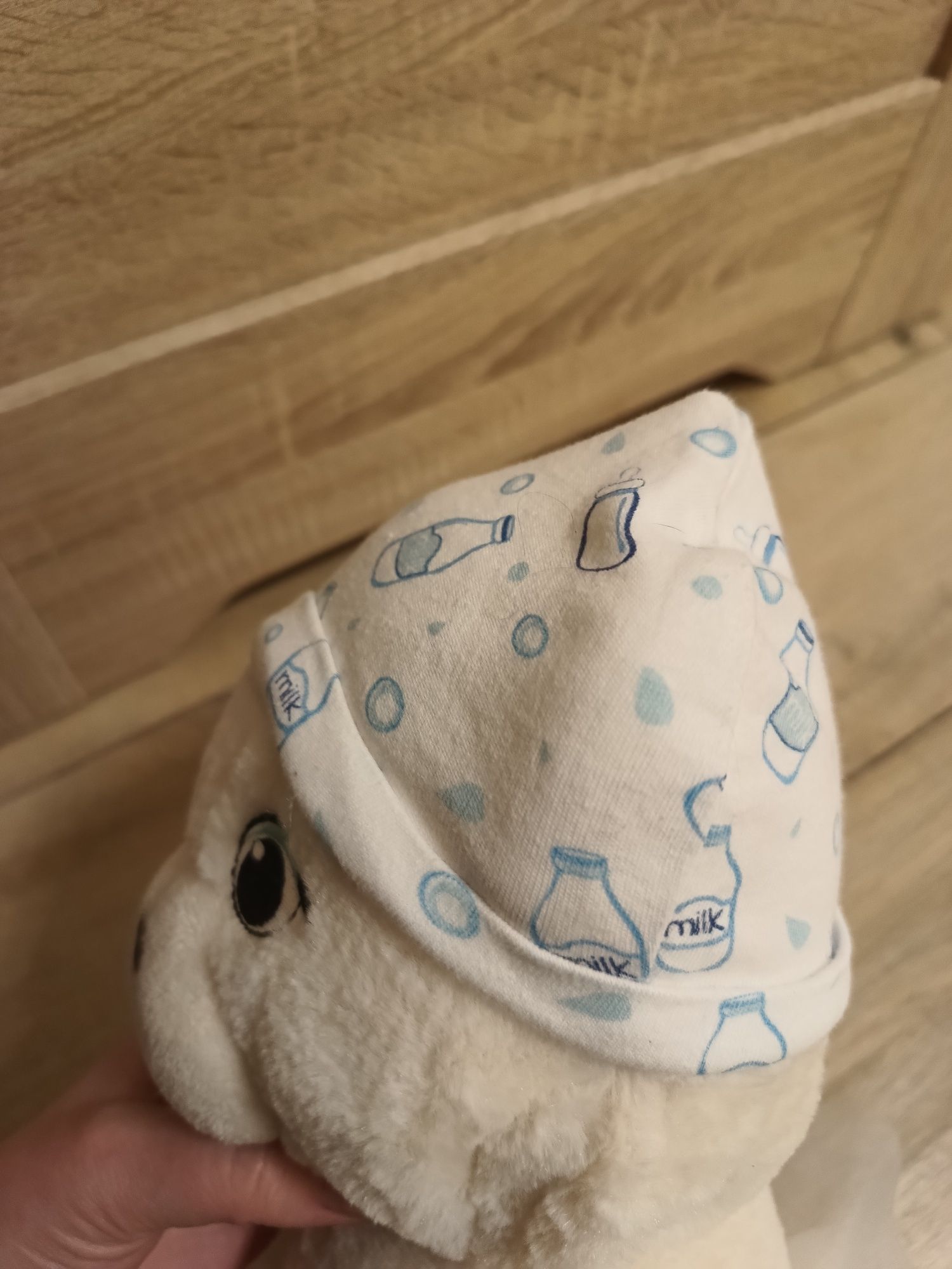 Biała dziecięca niemowlęca czapeczka w ozdobny wzór butelki mleka unis