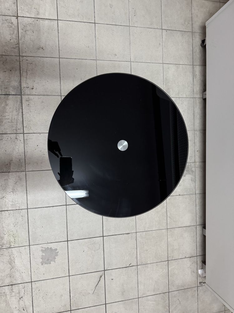 Mesa de apoio com tampo de vidro preto.