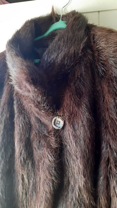 Casaco em pele de Lontra, em estado novo, com 2 bolsos e um botão.