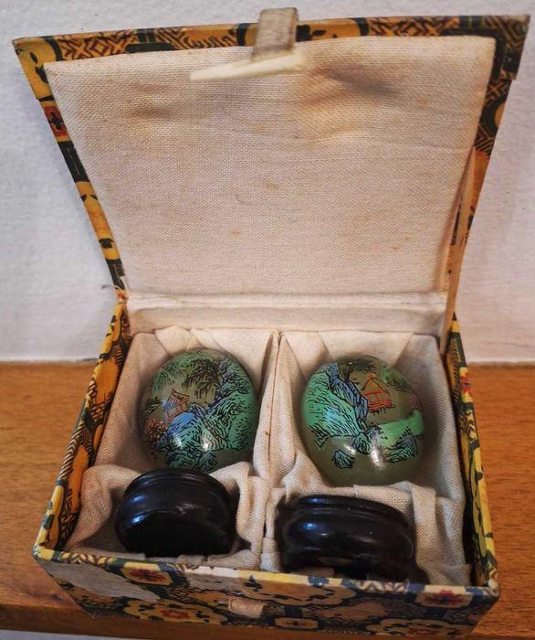 Par de pequenos ovos jade em suporte de madeira